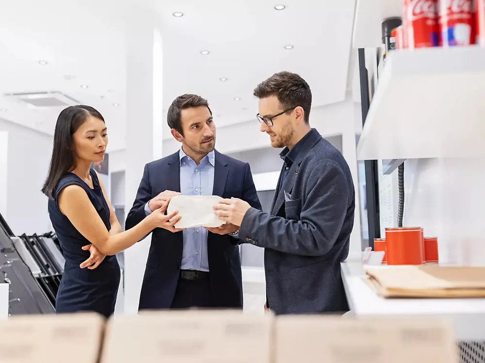 A customer experience tour guide presents a shoe sole to a group of customers in the Permanent Exhibition of the Henkel Adhesive Technologies - Inspiration Center Shanghai.
